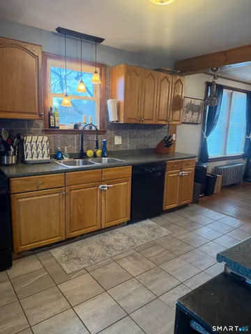 a kitchen with stainless steel appliances granite countertop a sink counter space cabinets and a large window