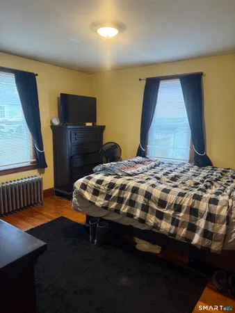 a bedroom with a bed and wooden floor