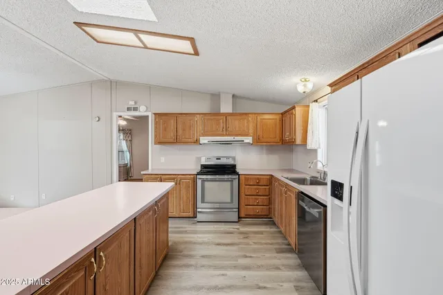 a kitchen with stainless steel appliances a dining table chairs and sink