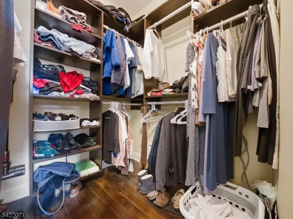 a view of walk in closet with clothes and shoes