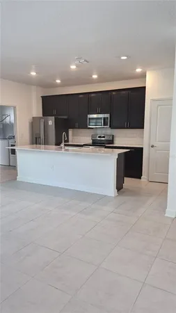 a view of kitchen with stainless steel appliances kitchen island a sink dishwasher a stove and a refrigerator with wooden floor