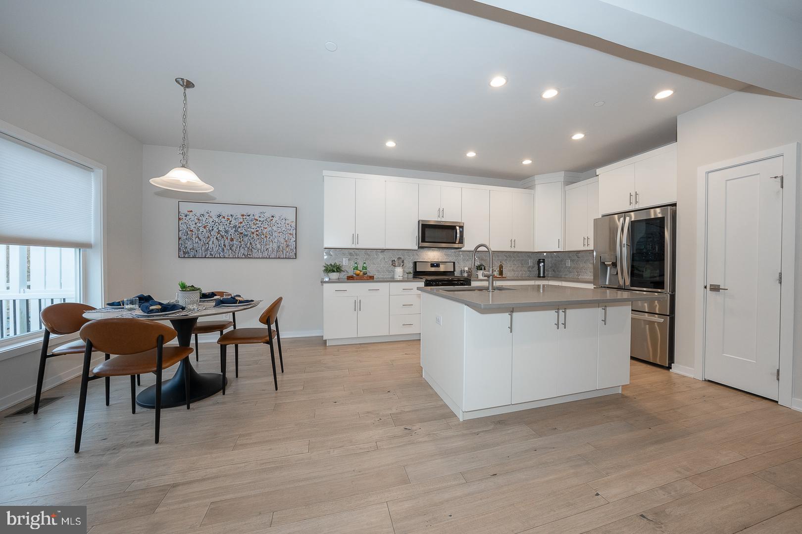 724 Switchman Road Media, PA 19063 - Photo 14 of 70 a kitchen with stainless steel appliances granite countertop a refrigerator a microwave oven a sink a dining table and chairs with wooden floor
