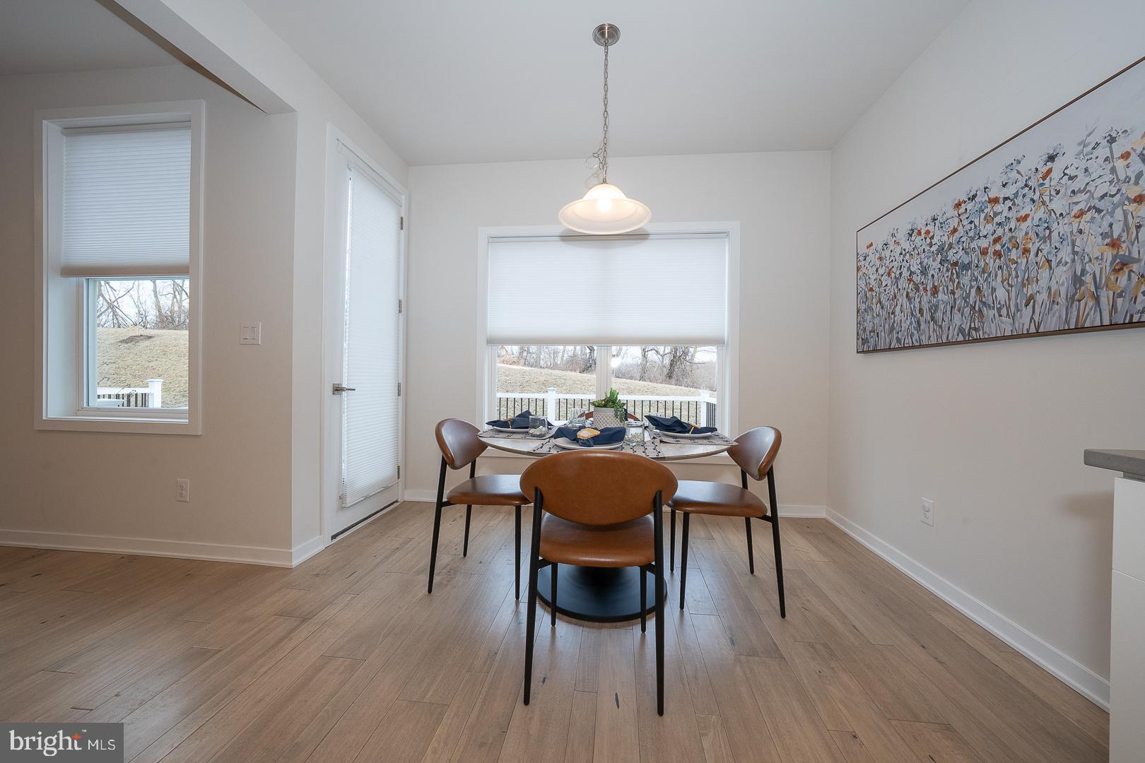 724 Switchman Road Media, PA 19063 - Photo 15 of 70 a dining room with wooden floor a chandelier a wooden table and chairs