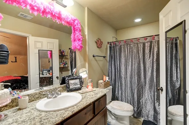 a bathroom with a sink vanity mirror and toilet