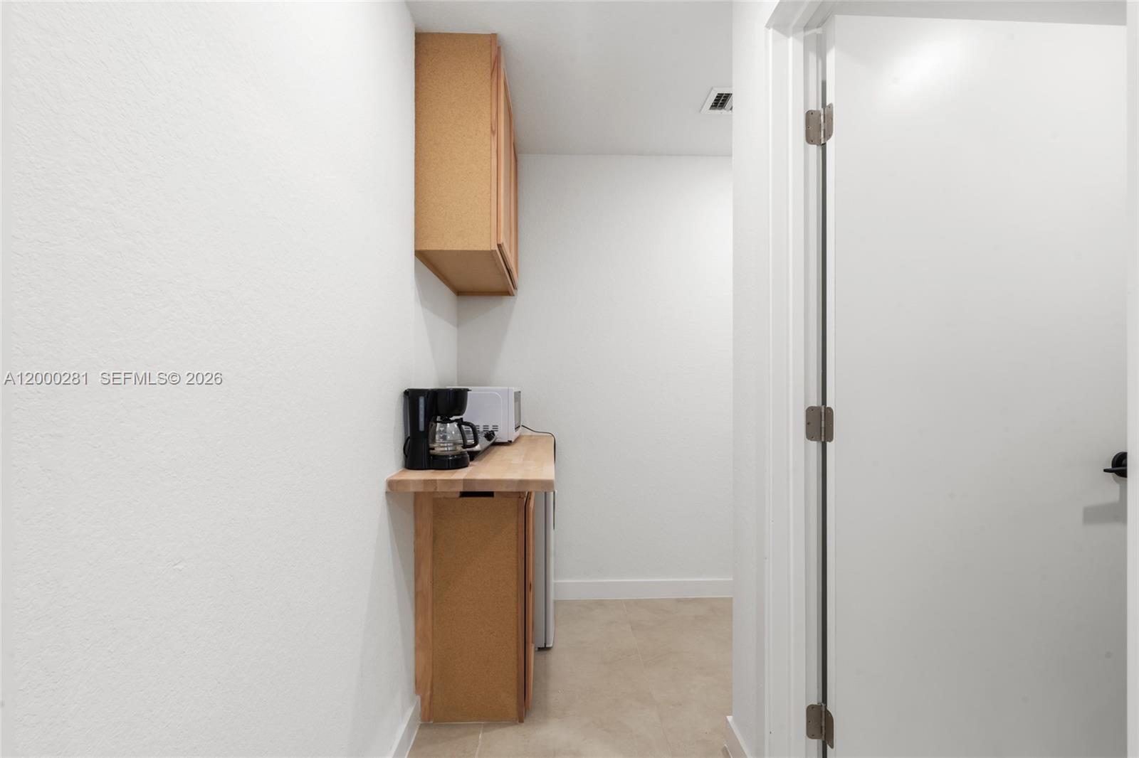 14513 Southwest 261st Street, Unit EFFICIENCY Homestead, FL 33032 - Photo 7 of 9 a room with a door and a table
