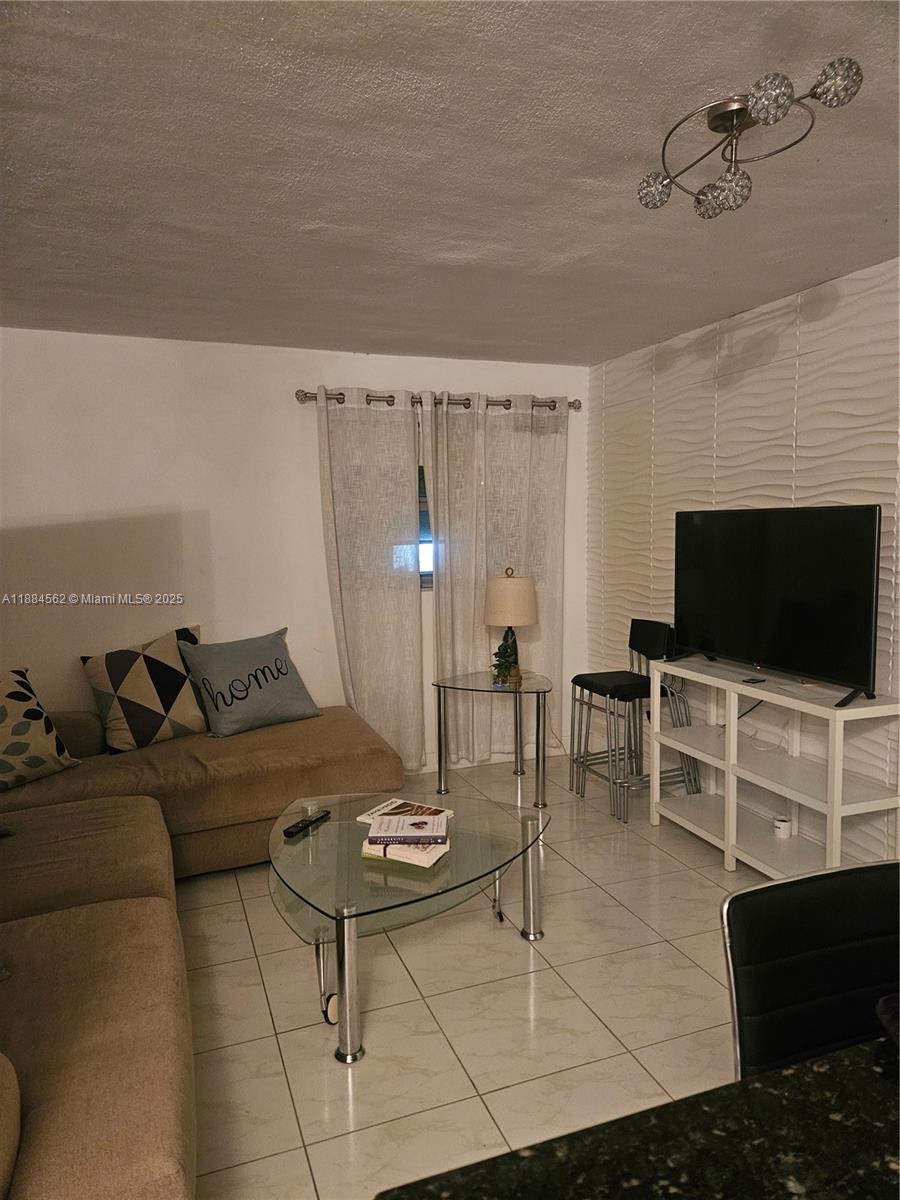 8425 Harding Avenue, Unit 1 Miami Beach, FL 33141 - Photo 2 of 16 a living room with furniture and a flat screen tv