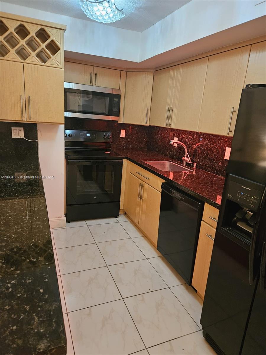 8425 Harding Avenue, Unit 1 Miami Beach, FL 33141 - Photo 5 of 16 a kitchen with granite countertop a stove and a microwave