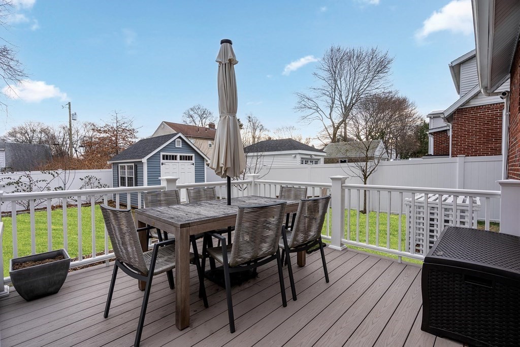 70 Falmouth Road Newton, MA 02465 - Photo 23 of 29 a view of a roof deck with table and chairs a barbeque with wooden floor and fence