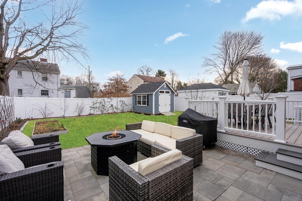 70 Falmouth Road Newton, MA 02465 - Photo 25 of 29 a view of a patio with couches chairs and a fire pit with a yard