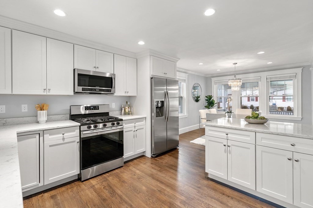 70 Falmouth Road Newton, MA 02465 - Photo 5 of 29 a kitchen with white cabinets and stainless steel appliances