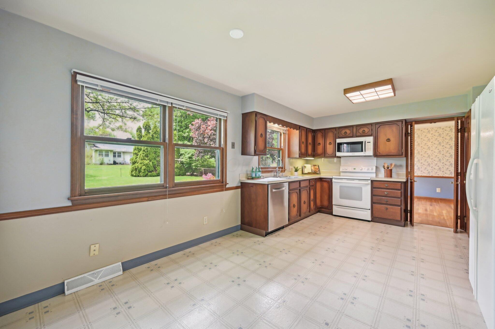 5917 Rocky Rill Road Columbus, OH 43235 - Photo 10 of 47 Eat-In Kitchen - Functional kitchen layout with large windows, ample cabinet storage, and newer stainless steel dishwasher (2020).