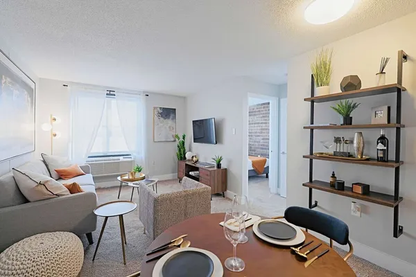 a living room with furniture kitchen view and a window