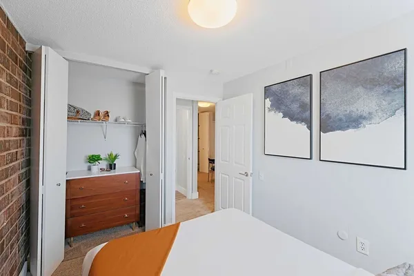 a bedroom with a bed and a painting on the wall