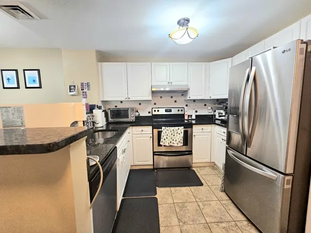 a large white kitchen with a large counter top