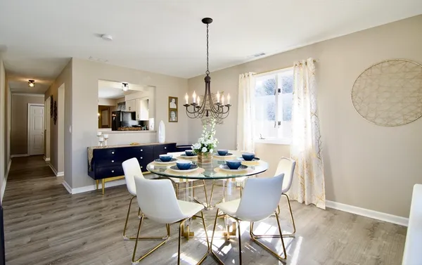 a view of a dining room and livingroom with furniture wooden floor a chandelier