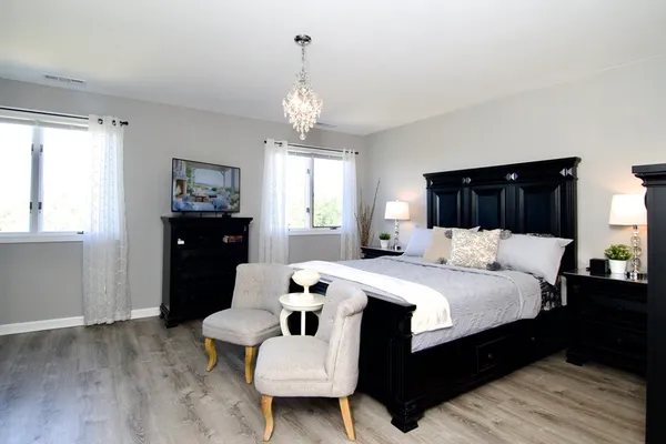 a bedroom with a bed and a chandelier