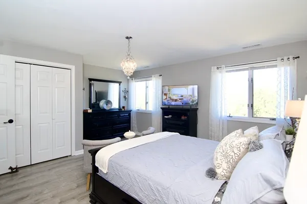 a bedroom with a bed dresser and a window