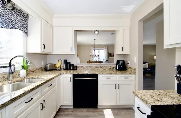 a kitchen with stainless steel appliances granite countertop a refrigerator a stove a sink and a dining table