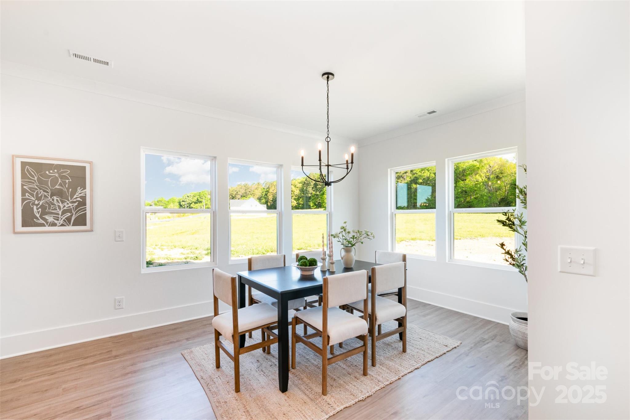 2133 Tite Road Stanfield, NC 28163 - Photo 12 of 35 a dining room with furniture a chandelier and wooden floor