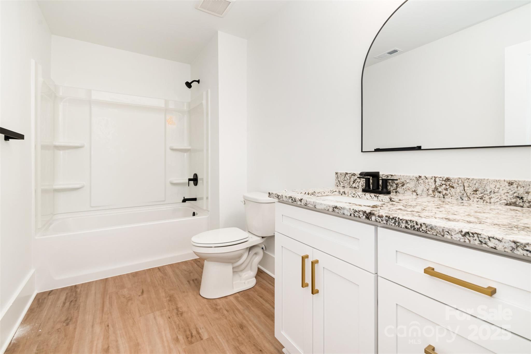 2133 Tite Road Stanfield, NC 28163 - Photo 23 of 35 a bathroom with a granite countertop sink a toilet and a bathtub