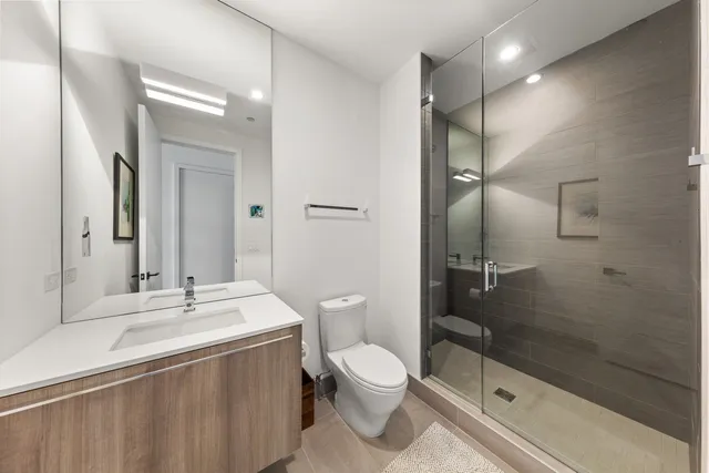 a bathroom with a sink a toilet and shower