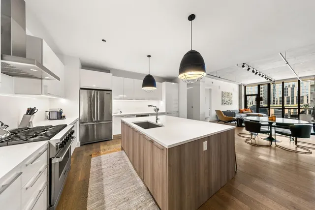 a kitchen with stainless steel appliances a stove center island cabinets and wooden floor