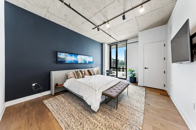 a living room with a bed and a flat screen tv