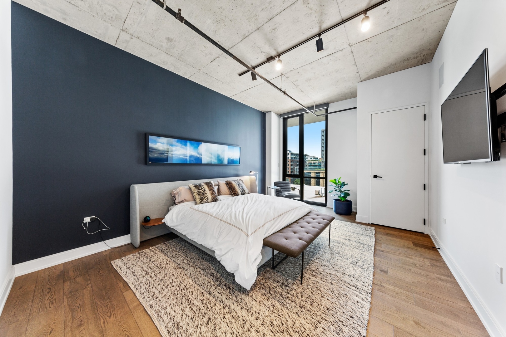 111 South Peoria Street, Unit 703 Chicago, IL 60607 - Photo 10 of 18 a living room with a bed and a flat screen tv