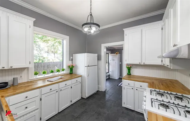 a kitchen with granite countertop a sink a stove and refrigerator