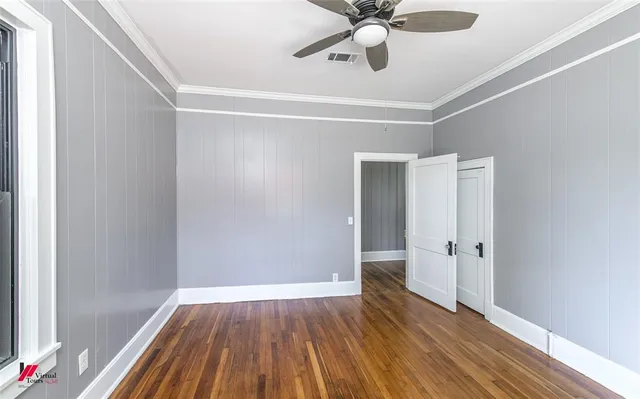 an empty room with window and chandelier fan