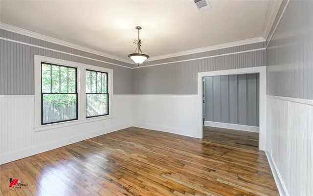 a view of empty room with wooden floor and windows