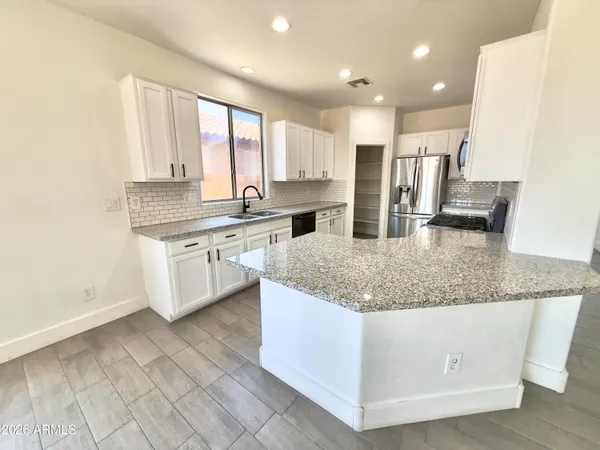 a view of a kitchen with a sink and dishwasher with wooden floor