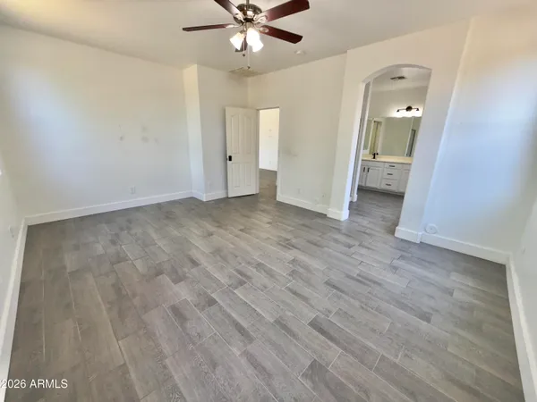 a view of an empty room with a window and wooden floor