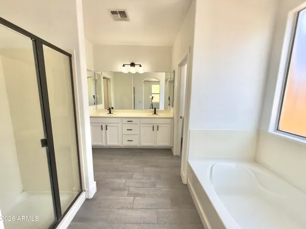 a spacious bathroom with a tub shower and sink
