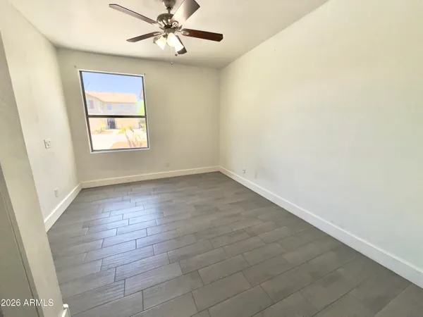 an empty room with a ceiling fan and carpet
