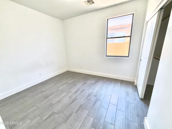 an empty room with wooden floor and entrance