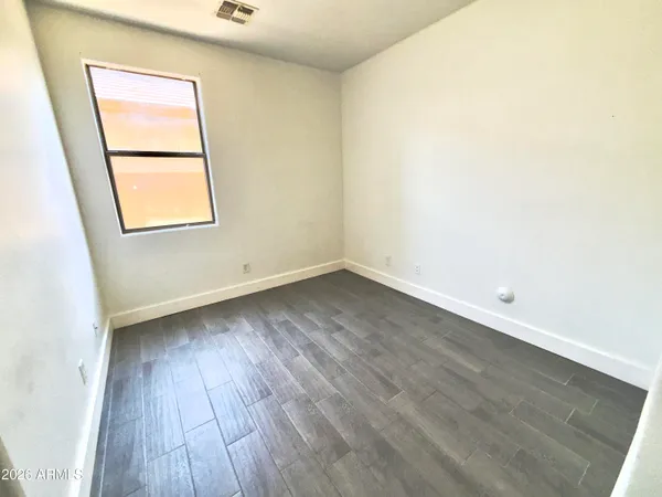 a view of an empty room with wooden floor