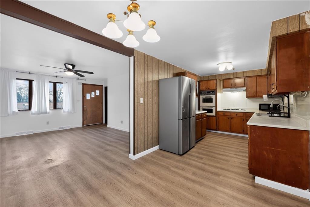 213 Tilford Road Pittsburgh, PA 15235 - Photo 20 of 20 a kitchen with stainless steel appliances granite countertop a refrigerator a sink dishwasher a stove and a dining table with wooden floor