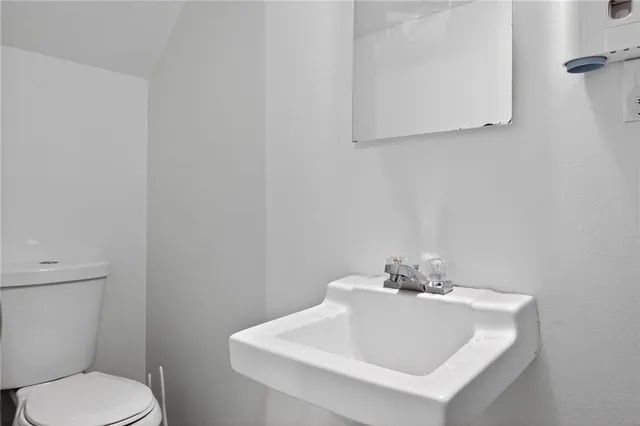 a white toilet sitting next to a white sink