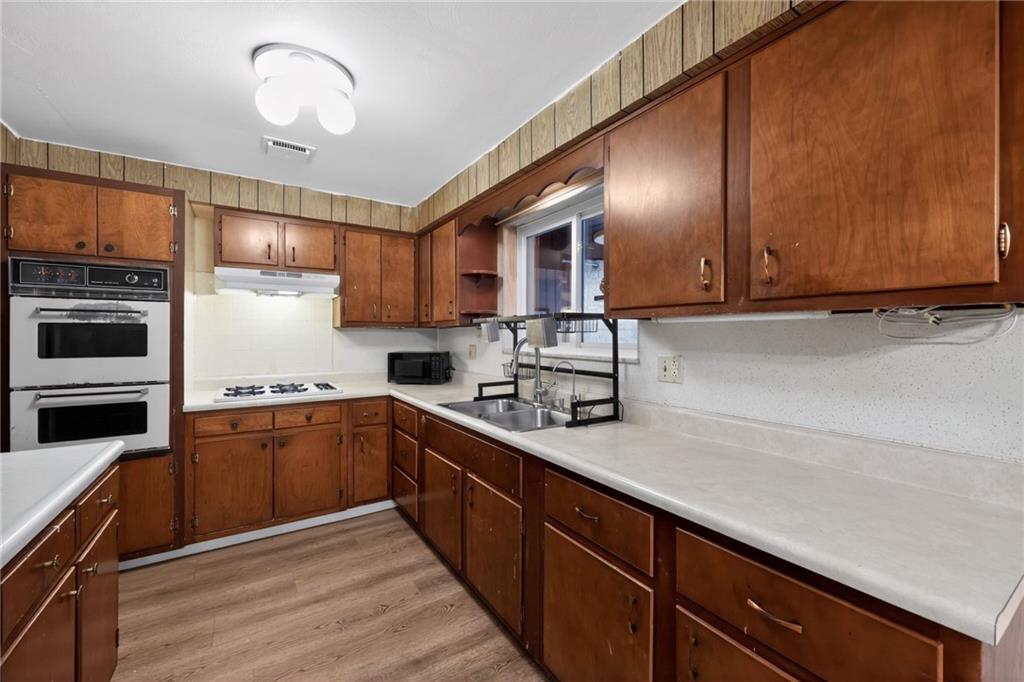 213 Tilford Road Pittsburgh, PA 15235 - Photo 5 of 20 a kitchen with stainless steel appliances granite countertop wooden cabinets a stove top oven a sink and dishwasher