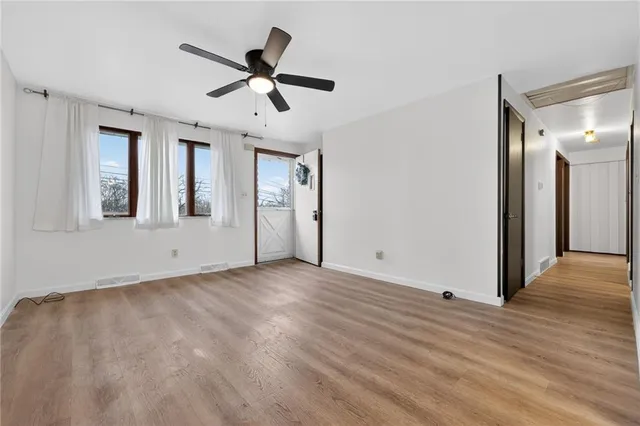 a view of a livingroom with a ceiling fan & wooden floor