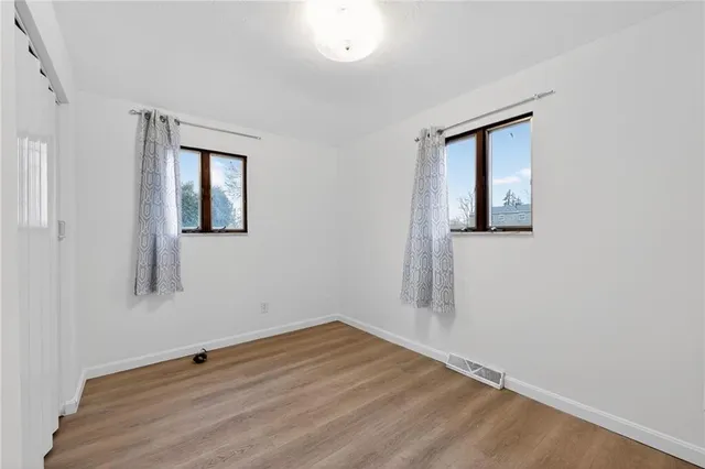 a view of a room with wooden floor and window