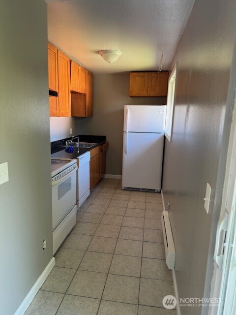 2716 South 258th Place Kent, WA 98032 - Photo 7 of 11 a kitchen with a cabinets and white appliances