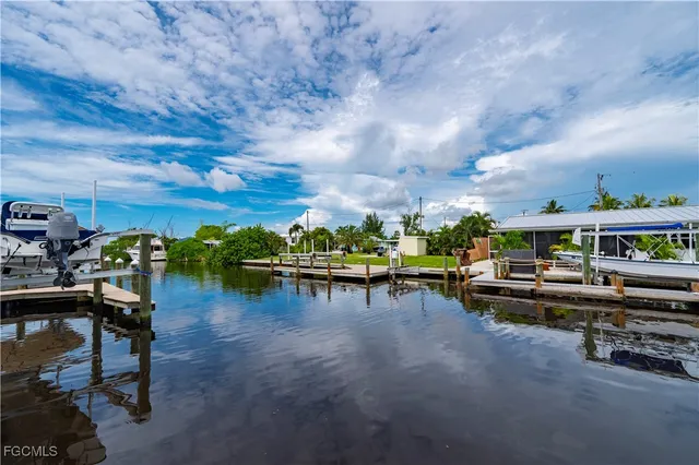 a view of a lake with a table and chairs in the patio