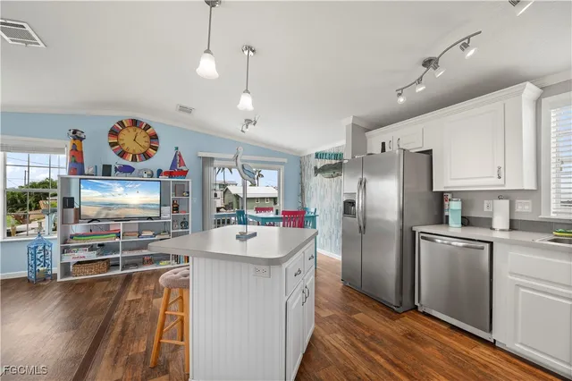 a kitchen with stainless steel appliances granite countertop a refrigerator a oven a sink and dishwasher with wooden floor