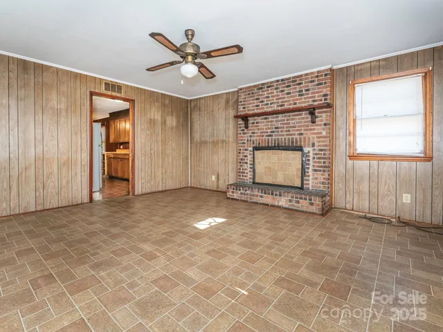 an empty room with windows and fireplace