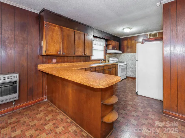 a kitchen with stainless steel appliances granite countertop a sink and a refrigerator