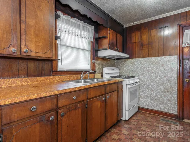 a kitchen with stainless steel appliances granite countertop a sink stove and cabinets