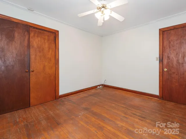 an empty room with wooden floor and closet area