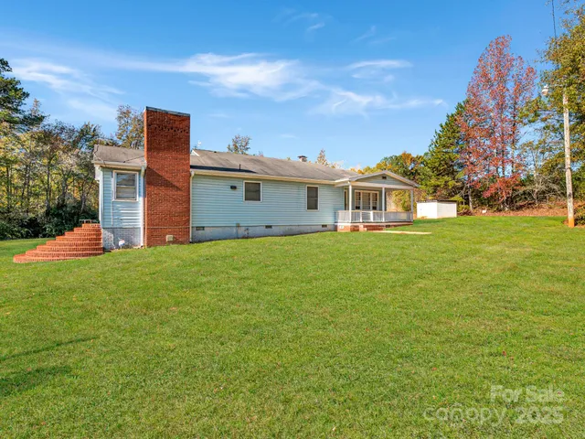 a front view of house with yard and trees in the background